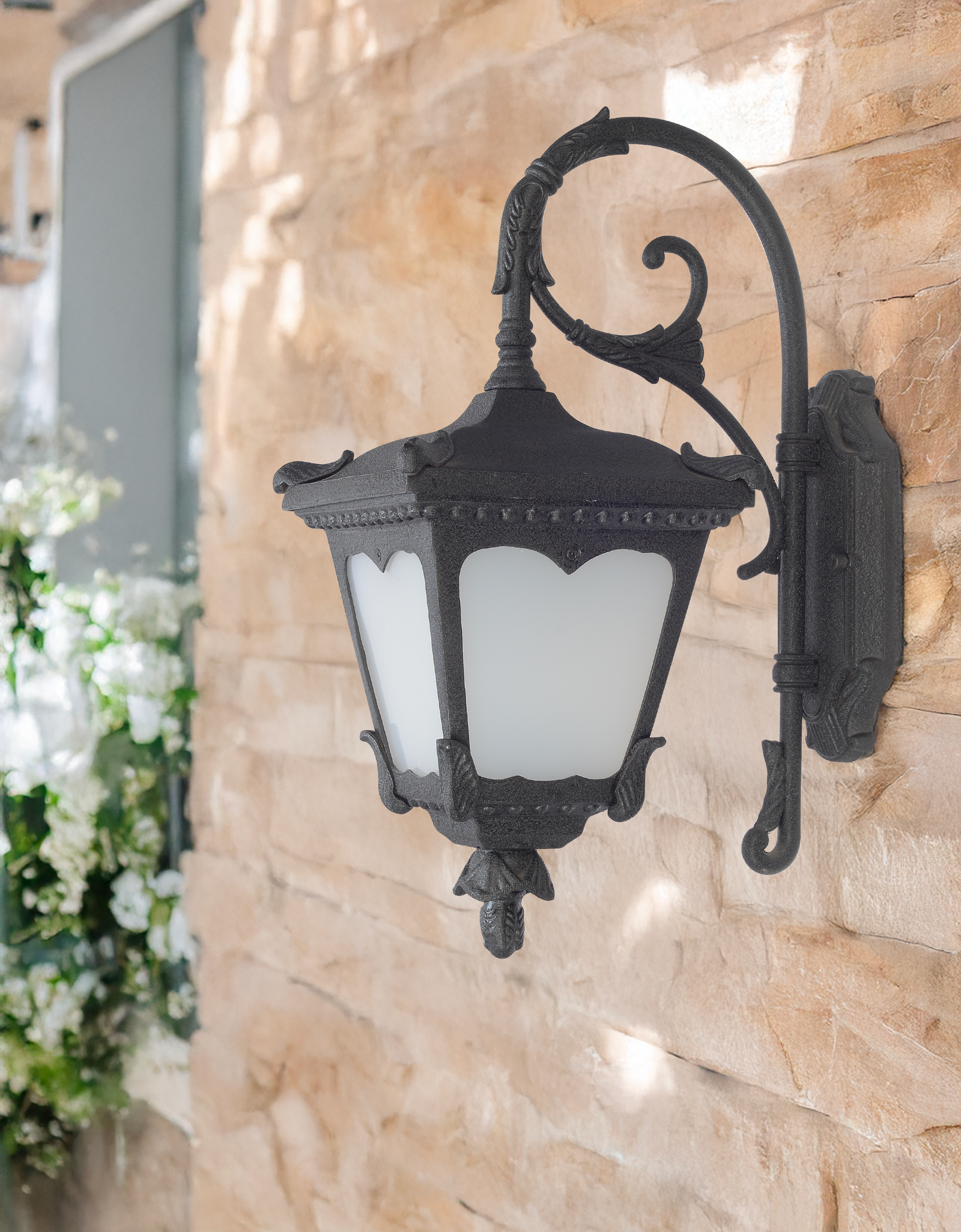 Parrot Wall Light by Kyess Lighting, artfully crafted with ornate details, mounted on a stone wall surrounded by lush foliage